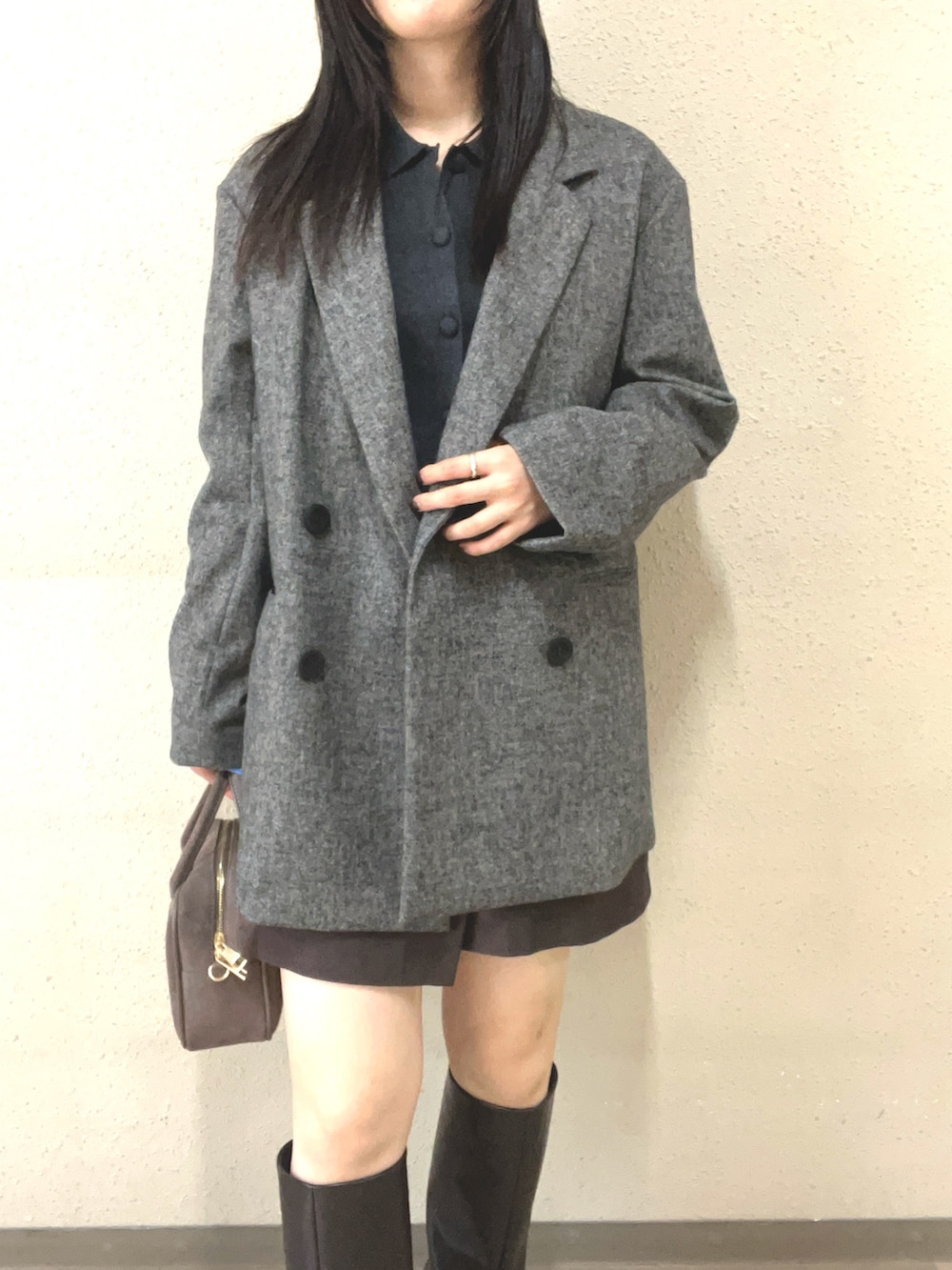 ブラウン系のブーツ、ブラック系のスカート、グレー系のテーラードジャケットを着用したレディースの秋コーディネートの3枚目の写真