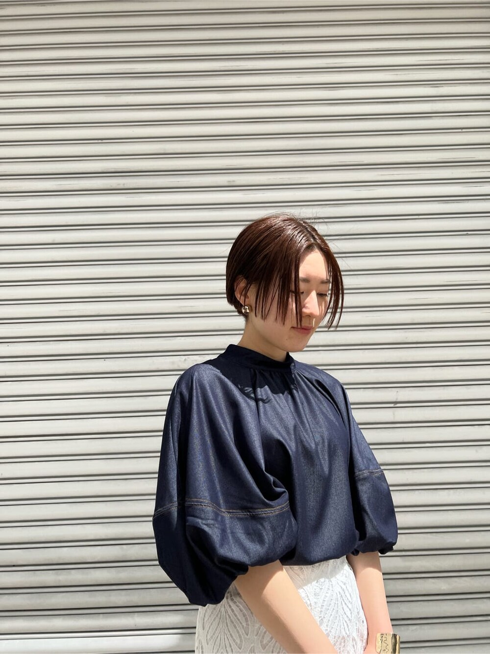 ホワイト系のハンドバッグ、ブルー系のシャツ/ブラウス、ホワイト系のスカートを着用したレディースの春コーディネートの3枚目の写真