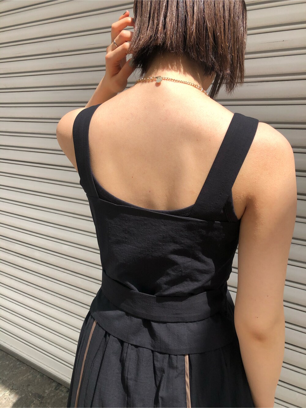 ブラウン系のパンプス、ホワイト系のハンドバッグ、ブラック系のワンピースを着用したレディースの春コーディネートの4枚目の写真