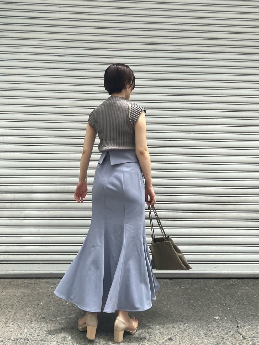 ベージュ系のハンドバッグ、その他のパンプス、ブルー系のスカートを着用したレディースの夏コーディネートの3枚目の写真