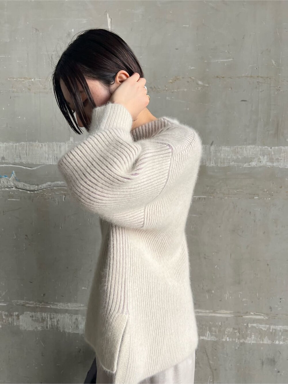 レッド系のブーツ、グレー系のスカート、パープル系のハンドバッグを着用したレディースの秋コーディネートの5枚目の写真