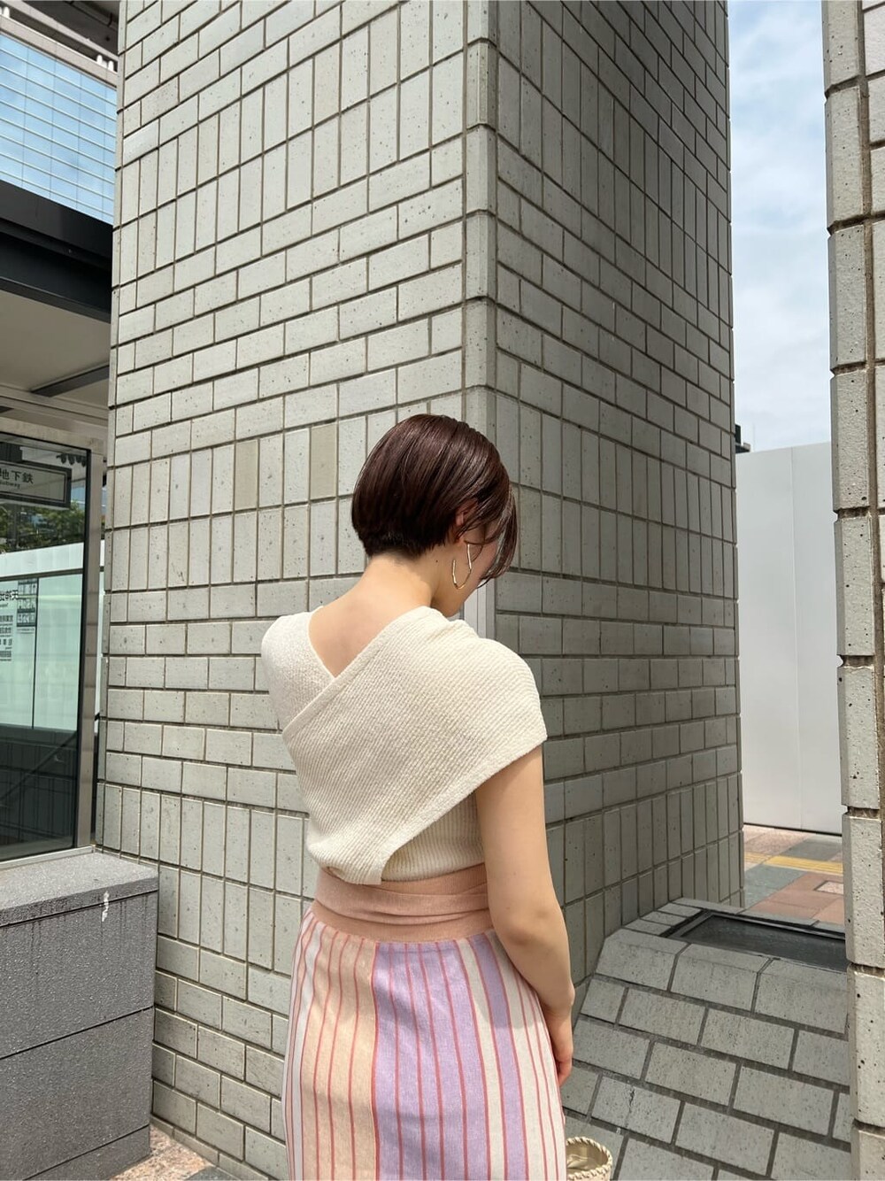 オレンジ系のスカート、その他のパンプス、ホワイト系のショルダーバッグを着用したレディースの春コーディネートの3枚目の写真