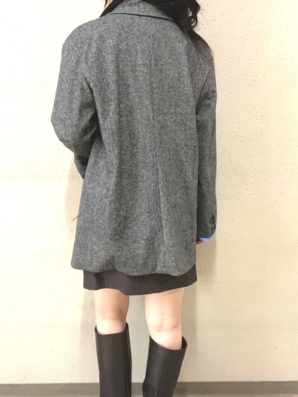 ブラウン系のブーツ、ブラック系のスカート、グレー系のテーラードジャケットを着用したレディースの秋コーディネートの6枚目の写真