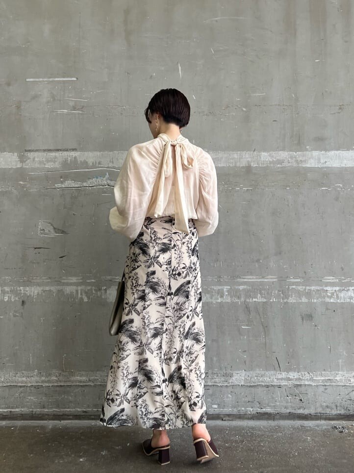 ベージュ系のハンドバッグ、ベージュ系のスカート、ブラウン系のシャツ/ブラウスを着用したレディースの夏コーディネートの3枚目の写真