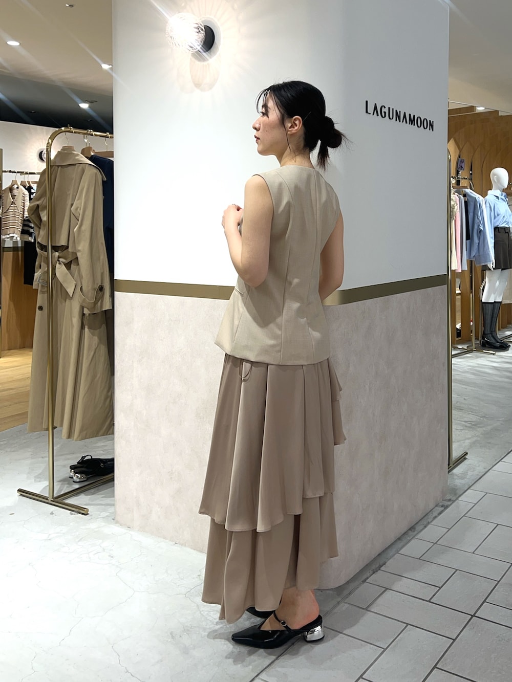 ベージュ系のワンピース、ブラック系のパンプス、ブラウン系のハンドバッグを着用したレディースの春コーディネートの2枚目の写真