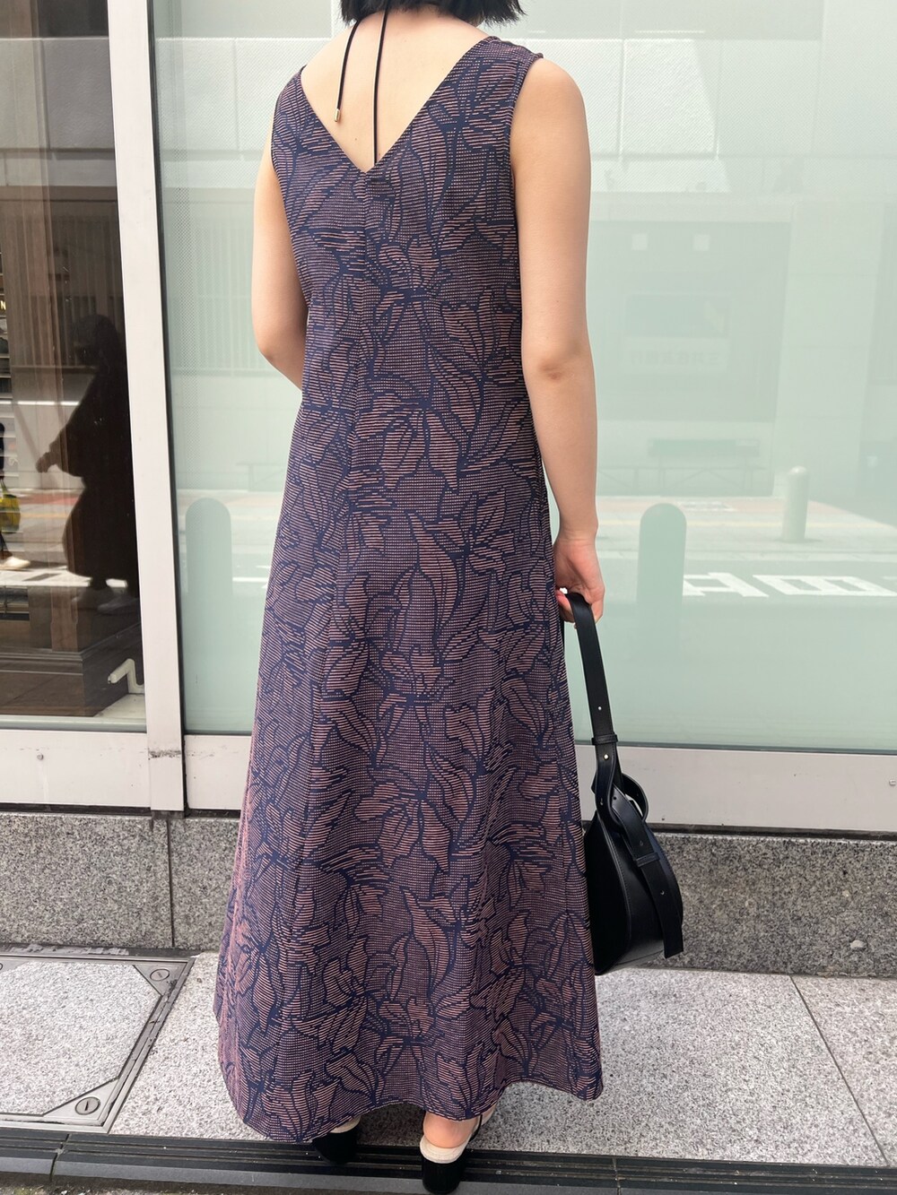 ブラック系のサンダル、ブラック系のワンピース、ホワイト系のシャツ/ブラウスを着用したレディースの春コーディネートの8枚目の写真