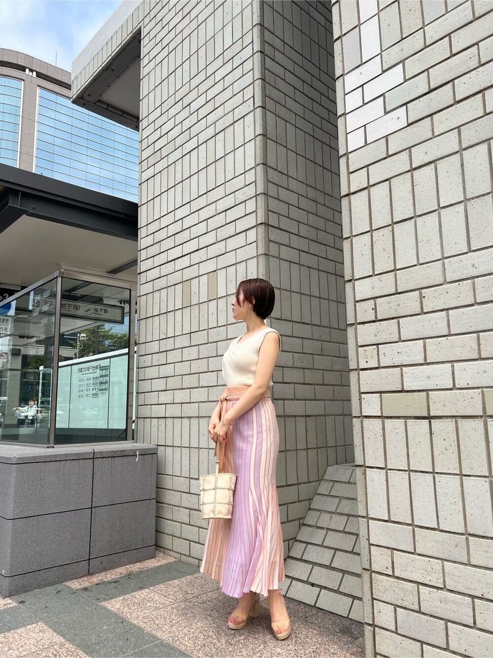 オレンジ系のスカート、その他のパンプス、ホワイト系のショルダーバッグを着用したレディースの春コーディネートの7枚目の写真