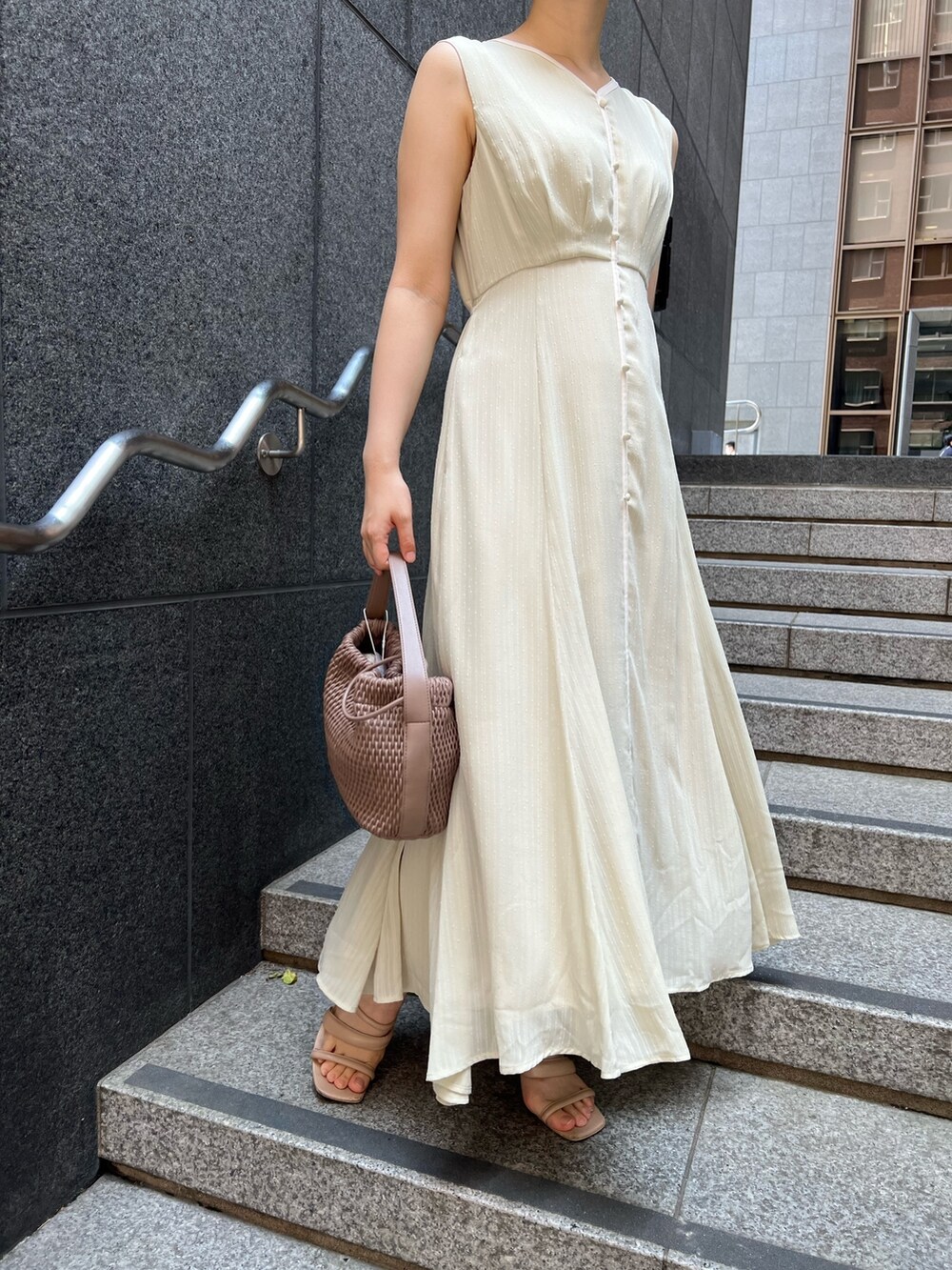 ベージュ系のサンダル、ホワイト系のハンドバッグ、グリーン系のワンピースを着用したレディースの夏コーディネートの3枚目の写真