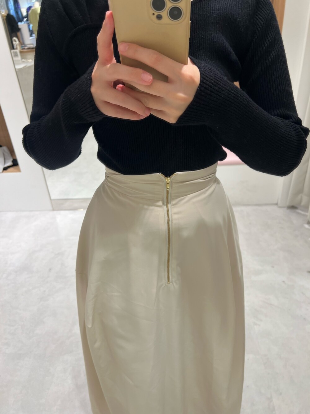 ホワイト系のスカート、ブラック系のニット/セーター、ベージュ系のブーツを着用したレディースの秋コーディネートの5枚目の写真