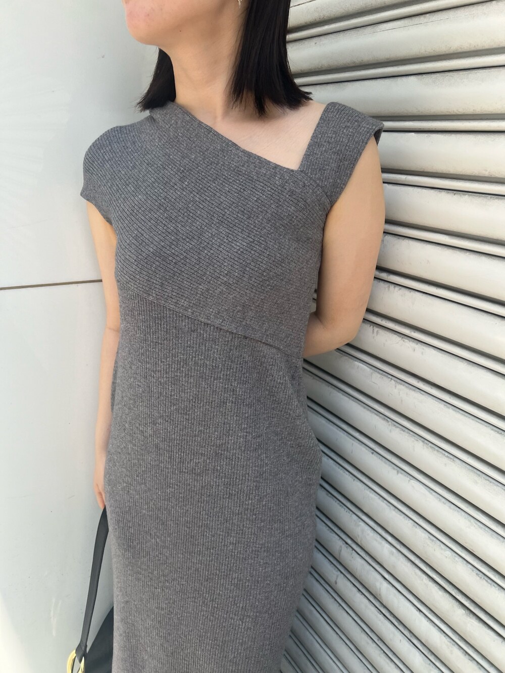 グレー系のワンピース、ブラック系のサンダル、ブラック系のショルダーバッグを着用したレディースの夏コーディネートの6枚目の写真