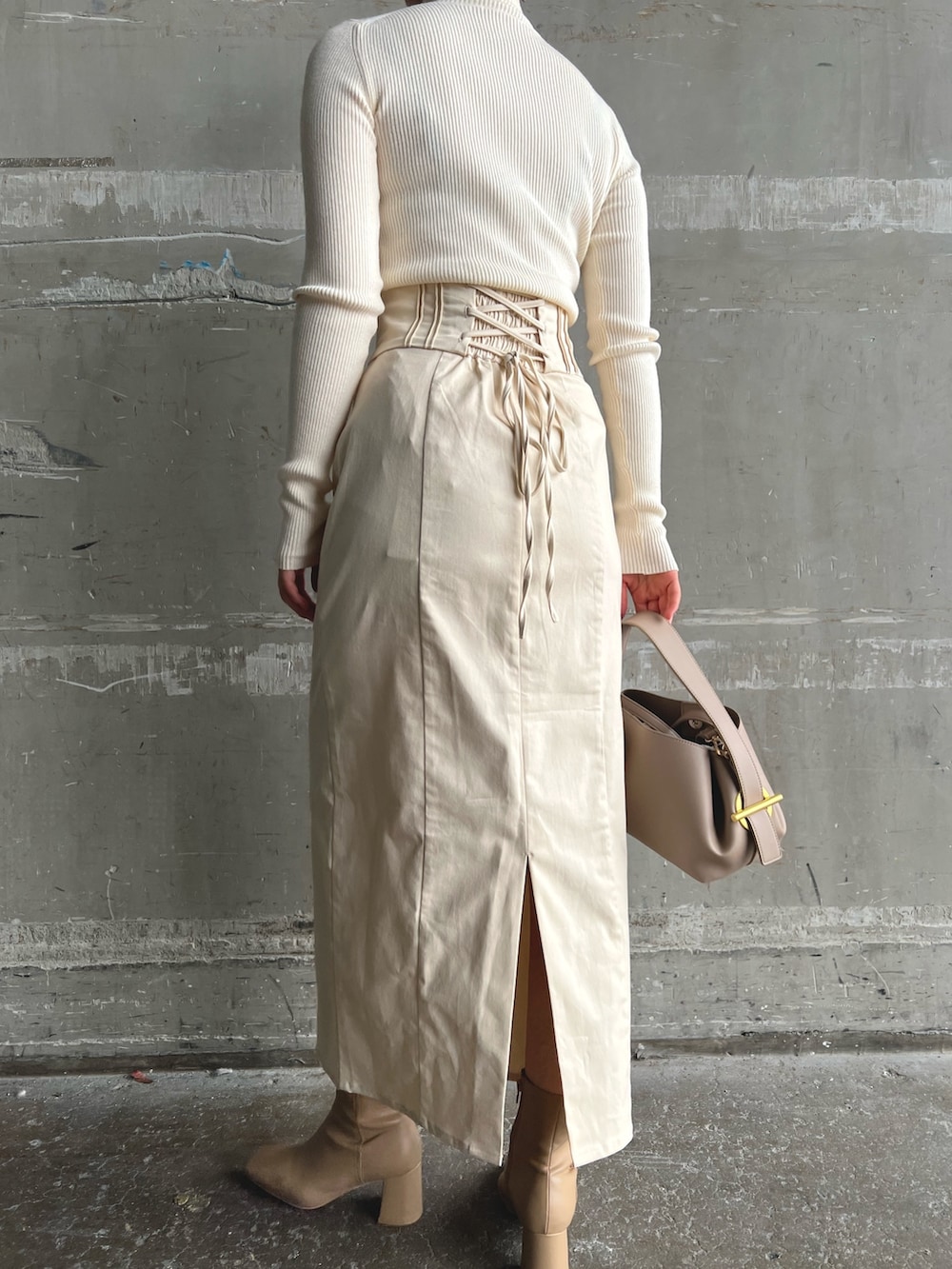 イエロー系のカーディガン/ボレロ、ベージュ系のブーツ、ホワイト系のニット/セーターを着用したレディースの秋コーディネートの8枚目の写真