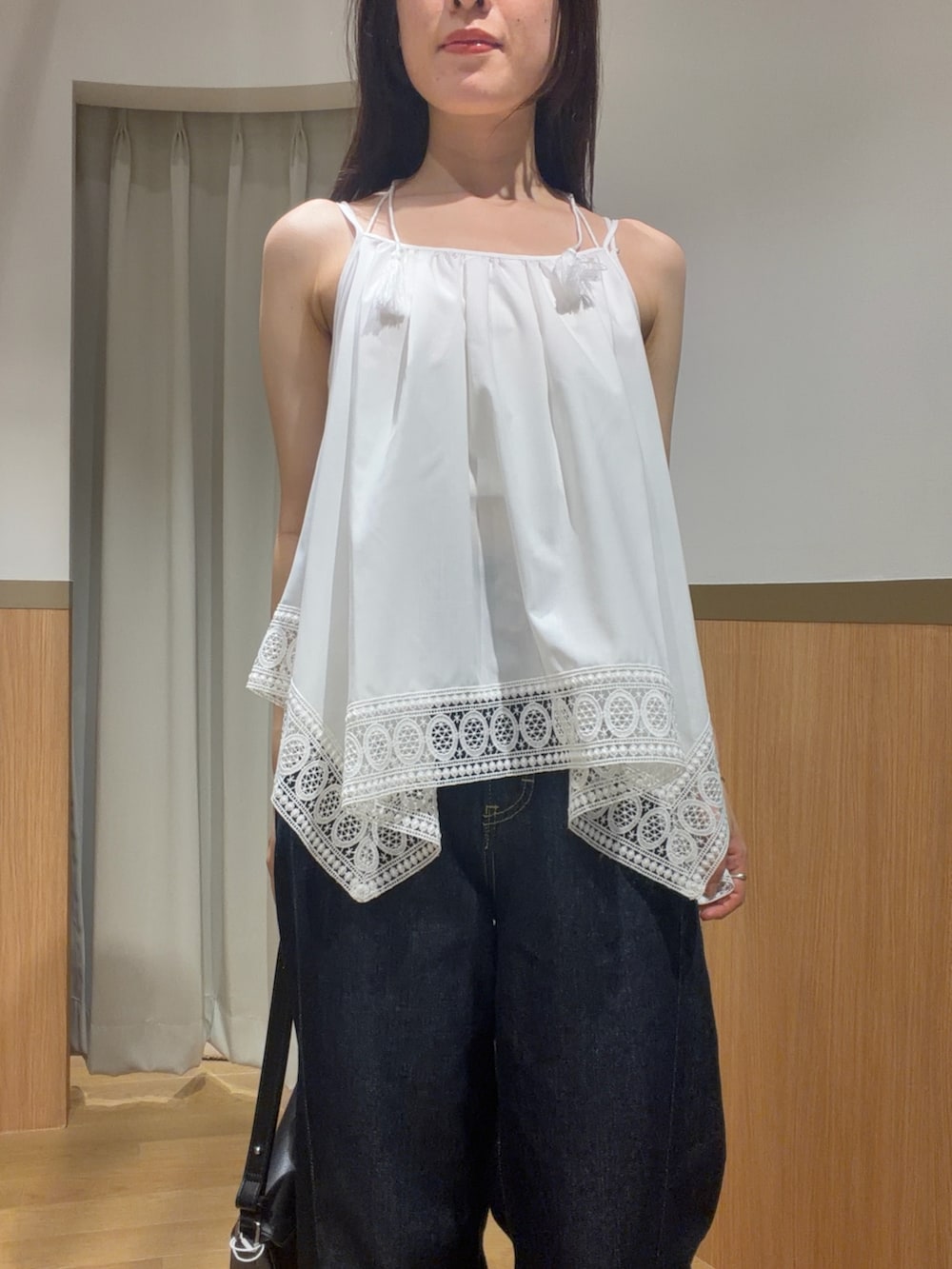ブルー系のデニムパンツ、ホワイト系のキャミソール、ブラウン系のサンダルを着用したレディースの夏コーディネートの4枚目の写真