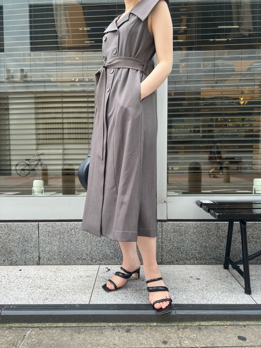 グレー系のワンピース、ブラック系のサンダル、ブラック系のハンドバッグを着用したレディースの夏コーディネートの9枚目の写真