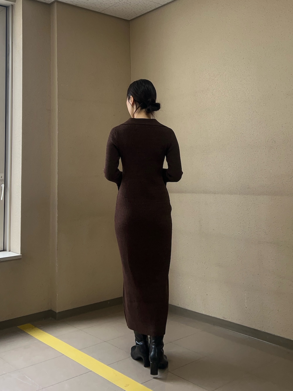 ブラック系のブーツ、ブラウン系のワンピース、ブラウン系のハンドバッグを着用したレディースの冬コーディネートの3枚目の写真