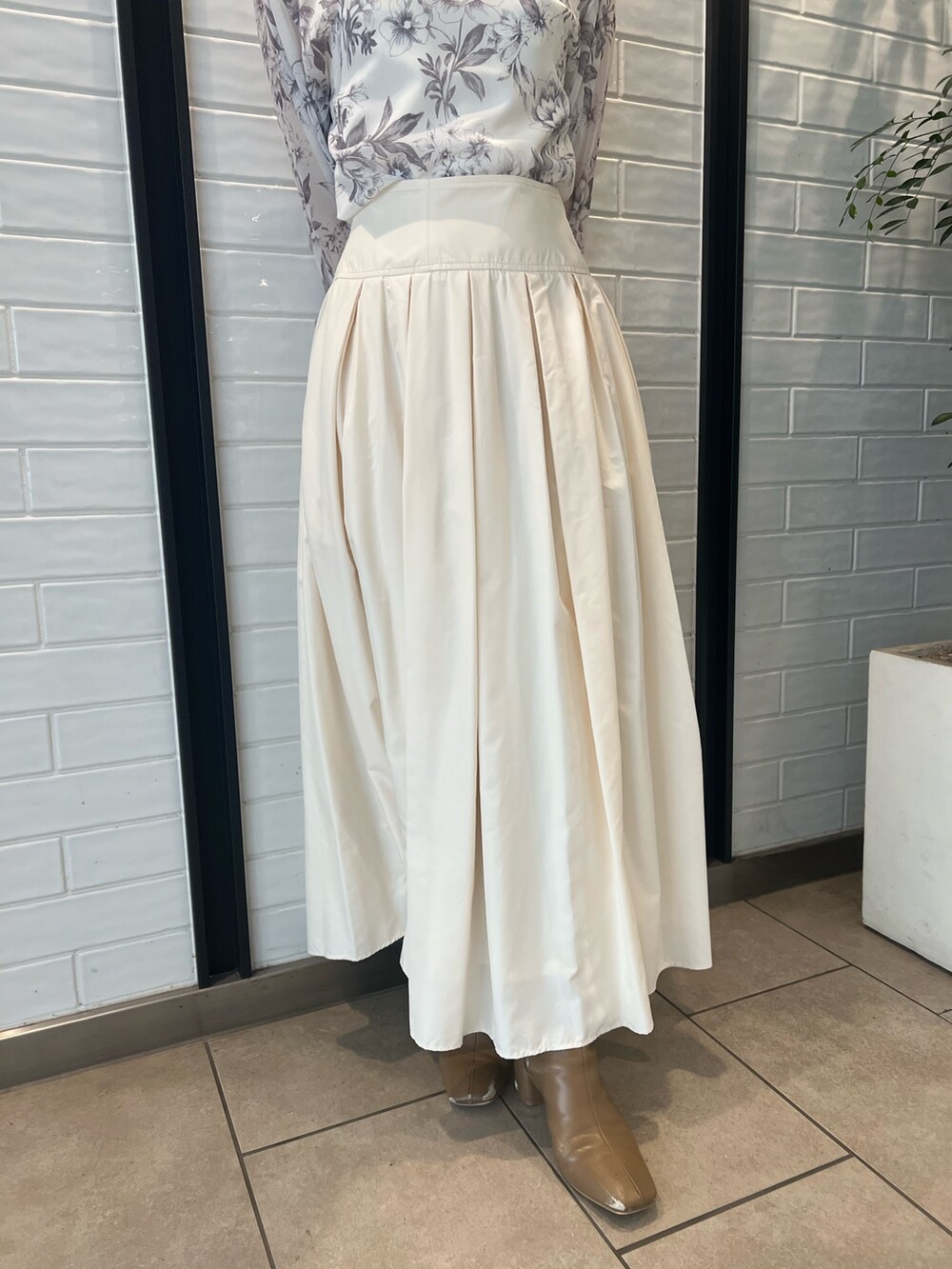 ホワイト系のスカート、ベージュ系のブーツ、ブラウン系のシャツ/ブラウスを着用したレディースの冬コーディネートの7枚目の写真