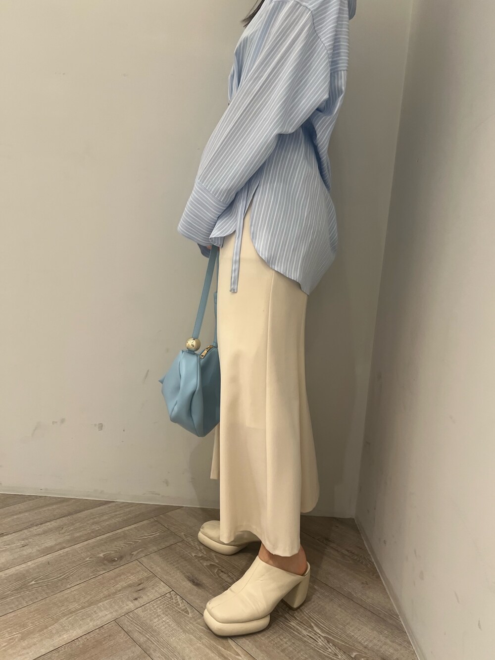 ブルー系のシャツ/ブラウス、ホワイト系のサンダル、ブルー系のショルダーバッグを着用したレディースの春コーディネートの8枚目の写真