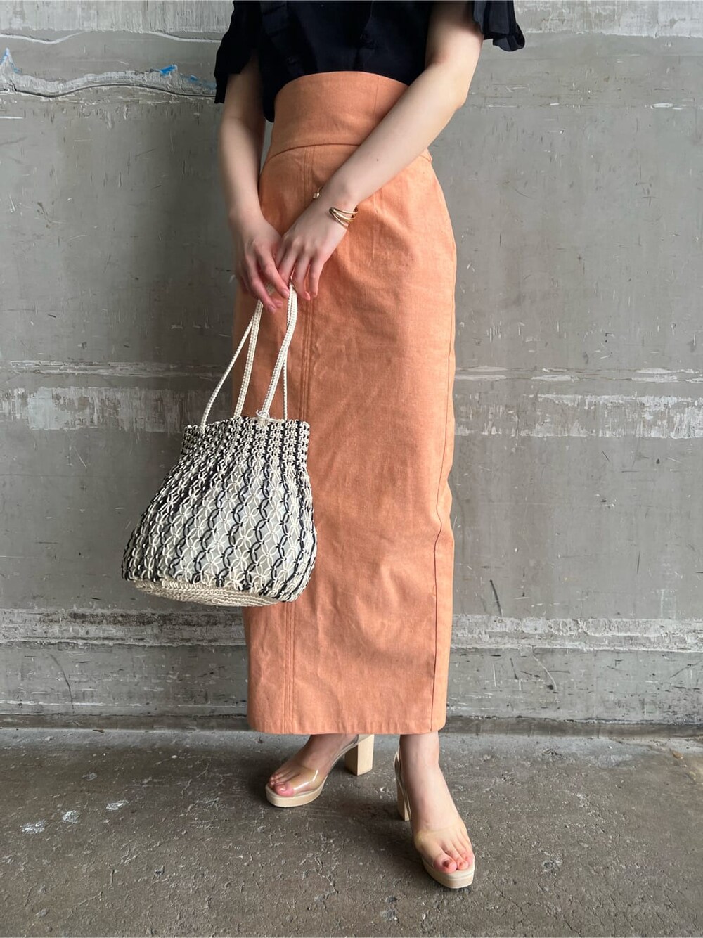 オレンジ系のスカート、その他のパンプス、ブラック系のニット/セーターを着用したレディースの春コーディネートの8枚目の写真