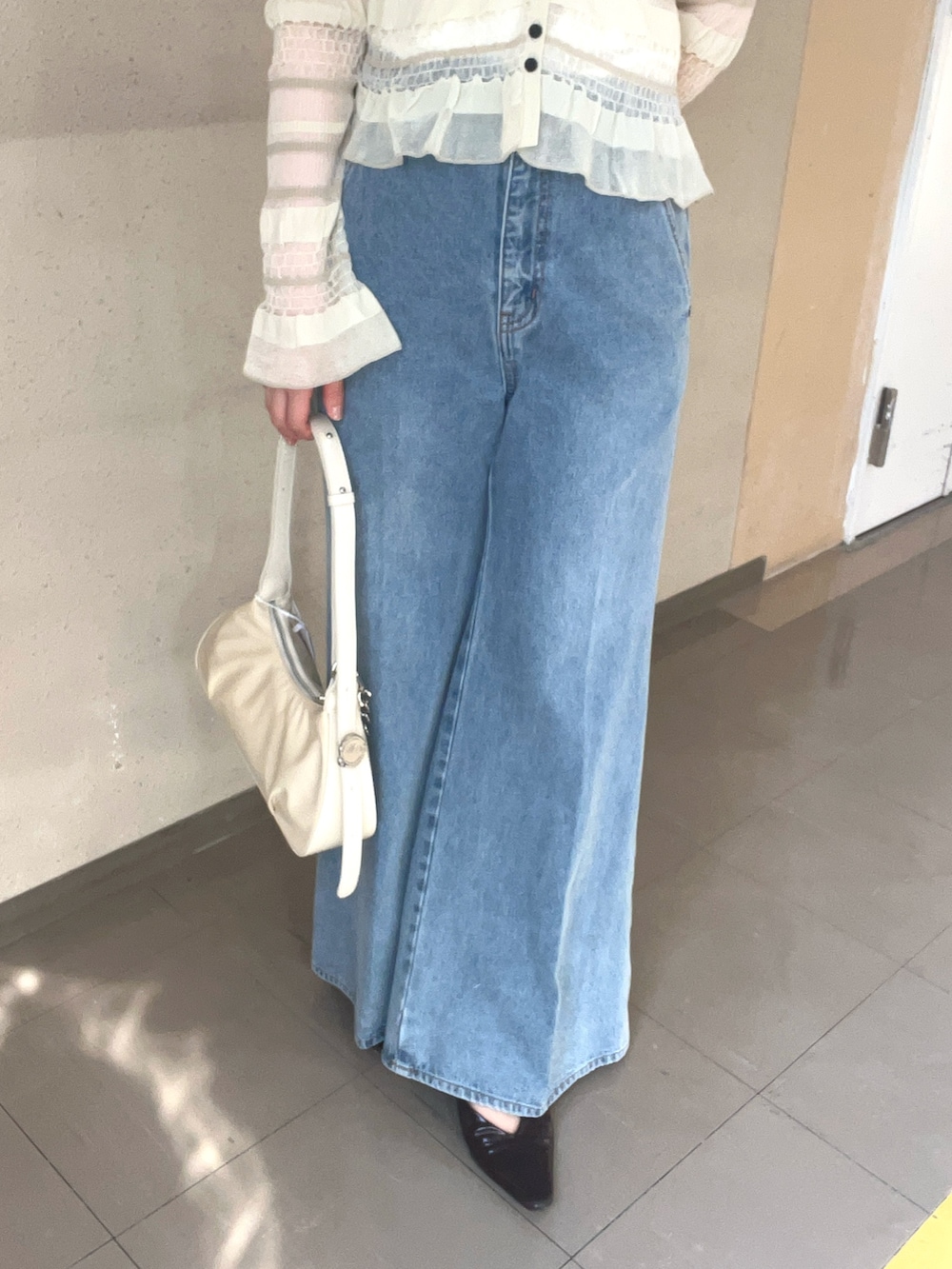 ホワイト系のニット/セーター、ブルー系のデニムパンツを着用したレディースの春コーディネートの4枚目の写真