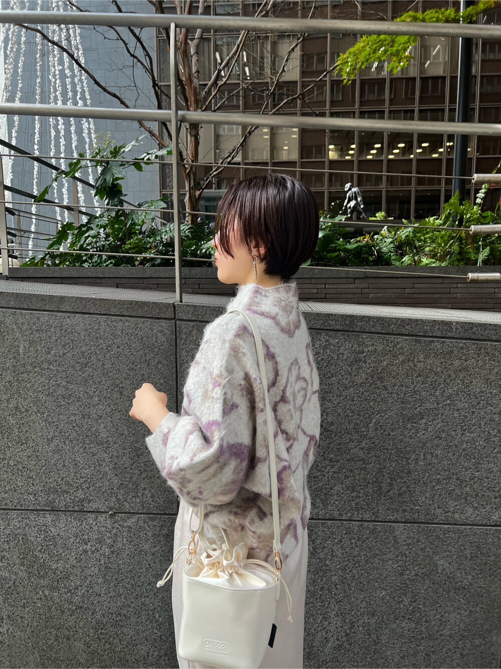 ホワイト系のハンドバッグ、グレー系のスカート、ベージュ系のその他シューズを着用したレディースの冬コーディネートの3枚目の写真