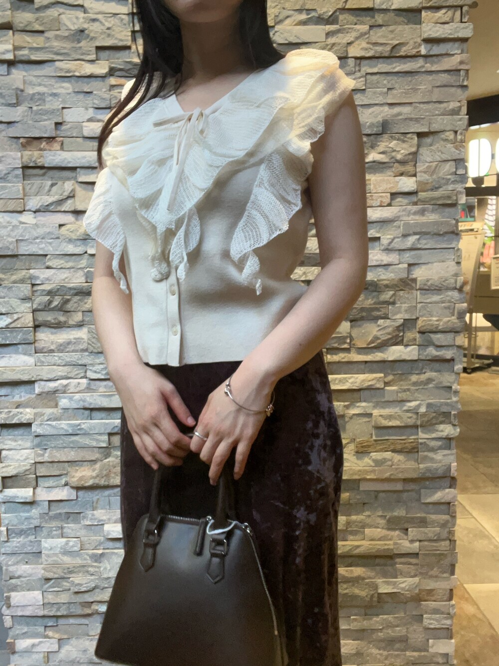 ブラウン系のボストンバッグ、ホワイト系のニット/セーター、ベージュ系のブーツを着用したレディースの秋コーディネートの4枚目の写真