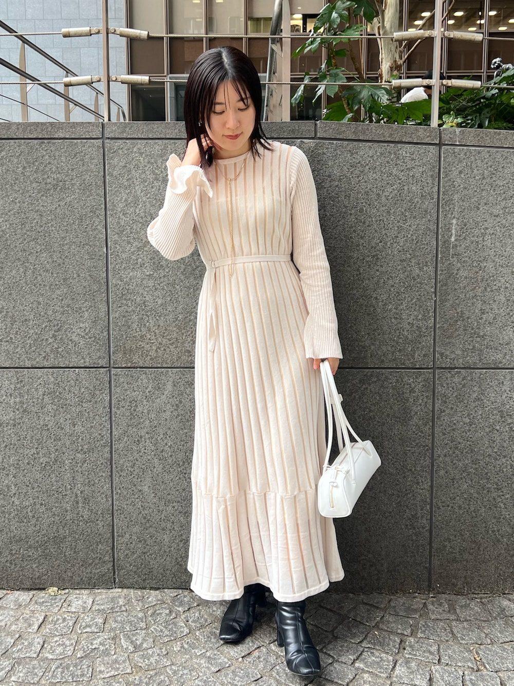 ブラック系のブーツ、ホワイト系のカーディガン/ボレロ、ホワイト系のショルダーバッグを着用したレディースの秋コーディネートの3枚目の写真