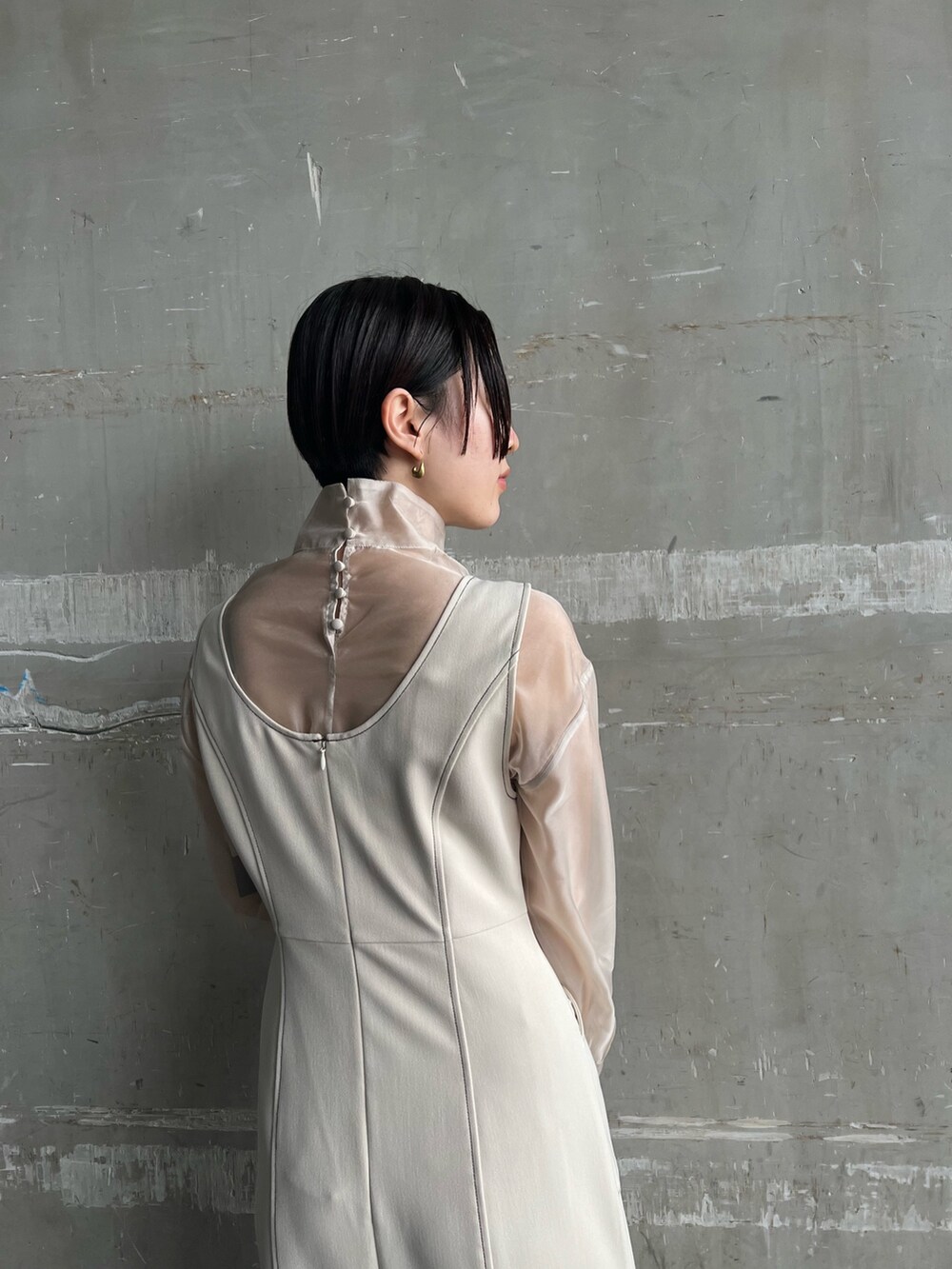 ホワイト系のカーディガン/ボレロ、ホワイト系のジャンパースカート、ベージュ系のシャツ/ブラウスを着用したレディースの秋コーディネートの7枚目の写真