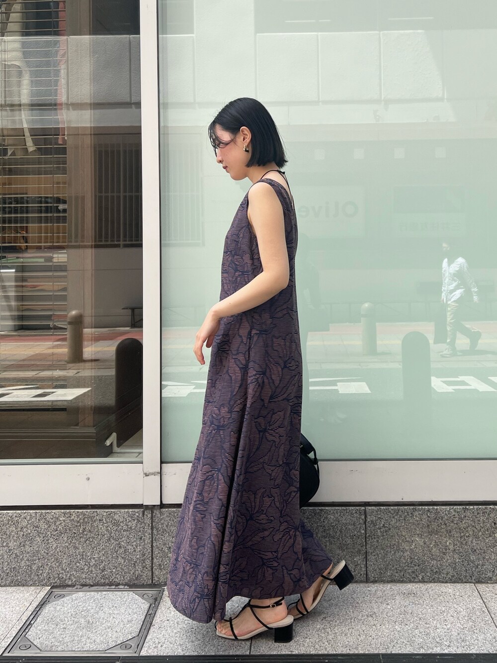 ブラック系のサンダル、ブラック系のワンピース、ホワイト系のシャツ/ブラウスを着用したレディースの春コーディネートの6枚目の写真