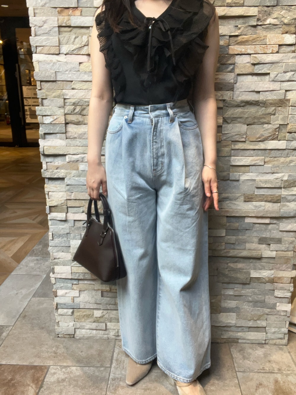 ブラック系のニット/セーター、ベージュ系のパンプス、ブラウン系のボストンバッグを着用したレディースの夏コーディネートの5枚目の写真