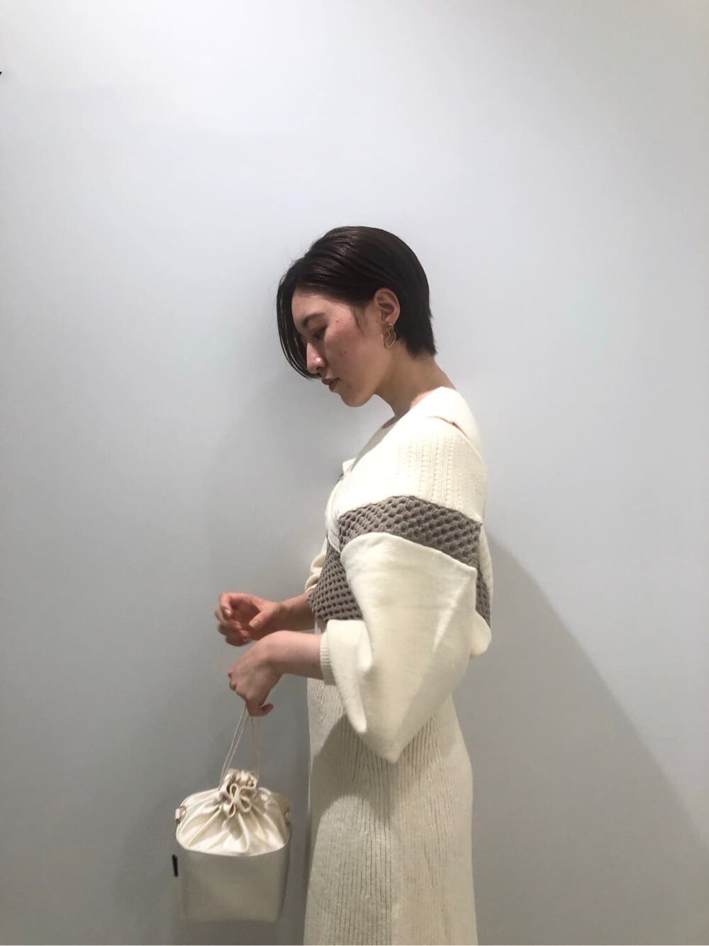 ベージュ系のその他シューズ、ホワイト系のワンピース、ホワイト系のハンドバッグを着用したレディースの秋コーディネートの7枚目の写真