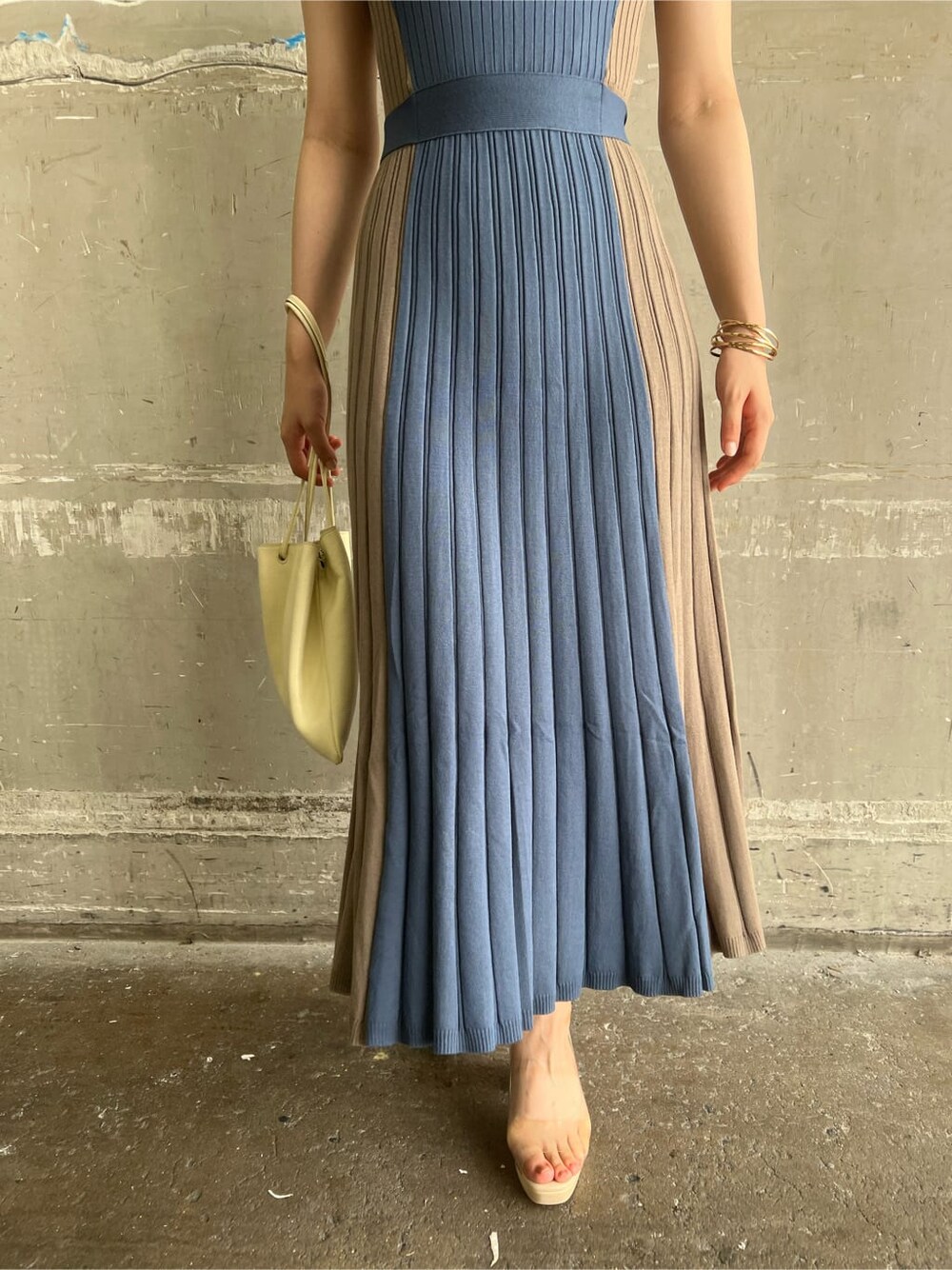 ホワイト系のハンドバッグ、ブルー系のワンピース、ゴールド系のピアス（両耳用）を着用したレディースの夏コーディネートの9枚目の写真