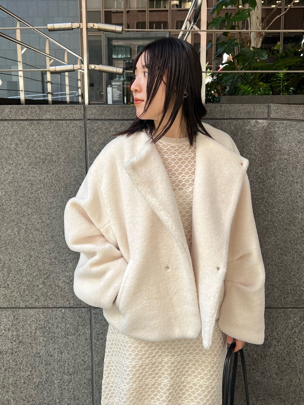 ホワイト系のブルゾン、ホワイト系のワンピース、ブラック系のブーツを着用したレディースの秋コーディネートの3枚目の写真