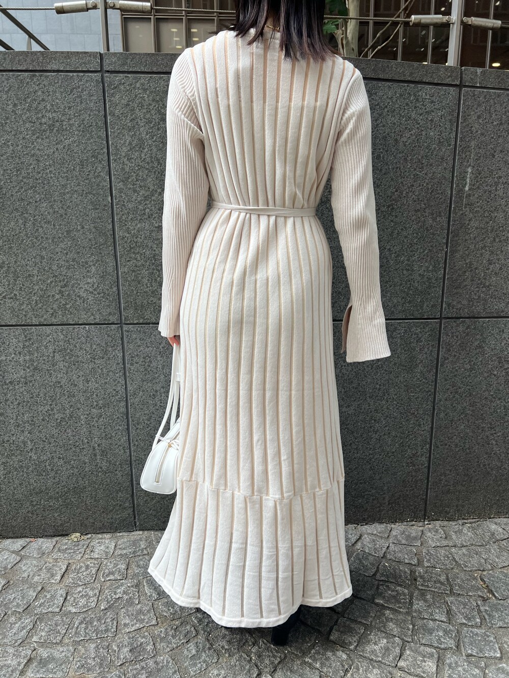 ブラック系のブーツ、ホワイト系のカーディガン/ボレロ、ホワイト系のショルダーバッグを着用したレディースの秋コーディネートの7枚目の写真