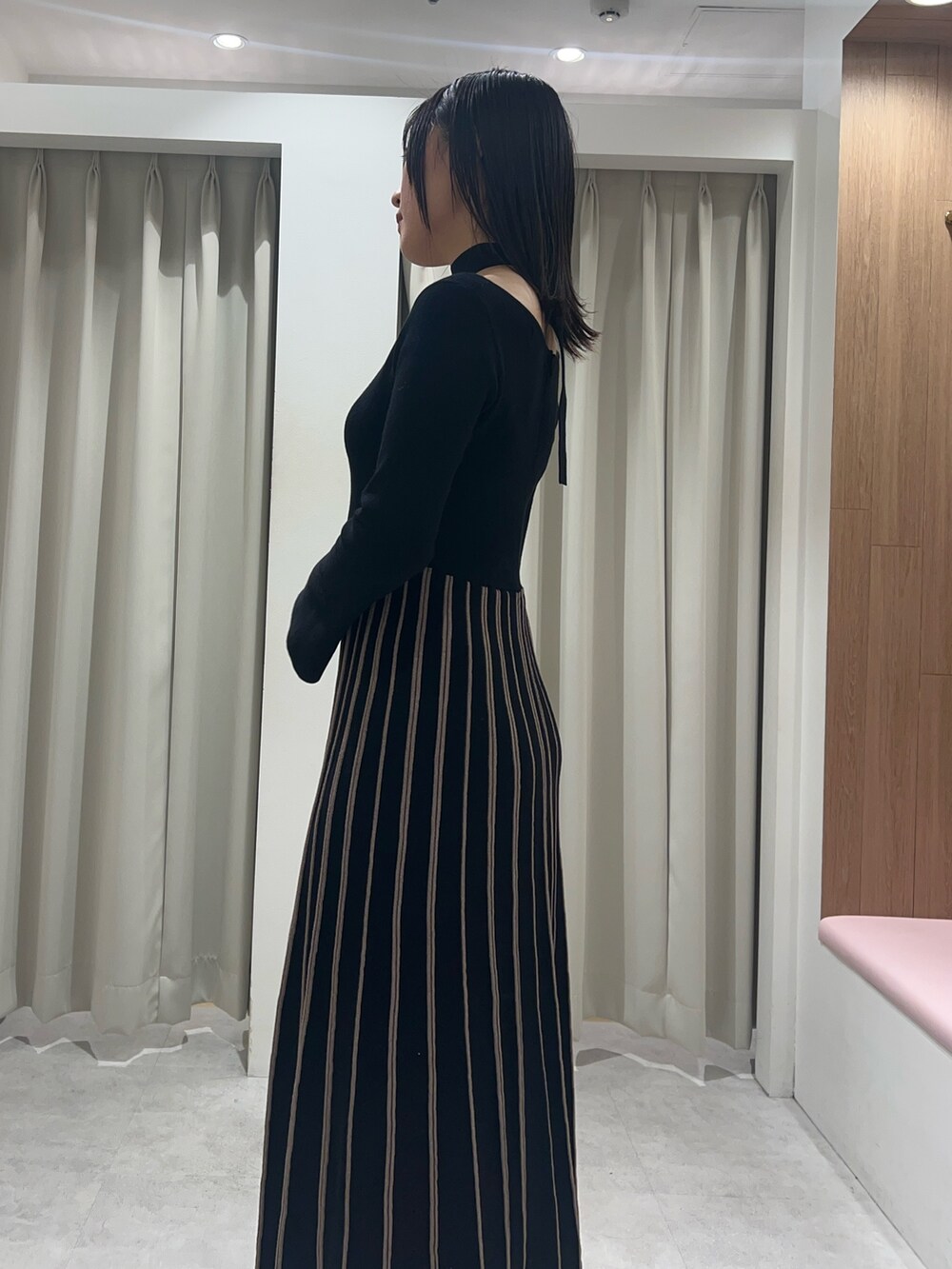 ブラック系のワンピース、ブラック系のブーツを着用したレディースの秋コーディネートの5枚目の写真