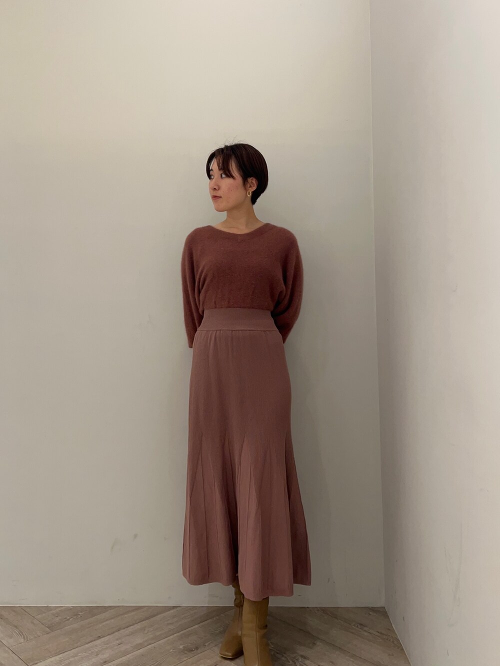 ピンク系のカーディガン/ボレロ、ピンク系のワンピース、ベージュ系のブーツを着用したレディースの秋コーディネートの3枚目の写真