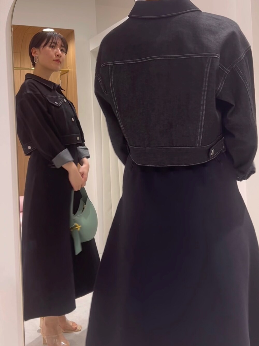 ベージュ系のサンダル、ブラック系のワンピース、ブラック系のデニムジャケットを着用したレディースの春コーディネートの2枚目の写真