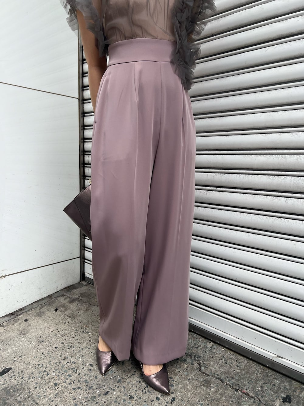 シルバー系のパンプス、ブラック系のチェスターコート、シルバー系のハンドバッグを着用したレディースの冬コーディネートの9枚目の写真