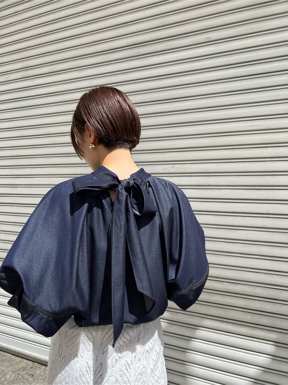 ホワイト系のハンドバッグ、ブルー系のシャツ/ブラウス、ホワイト系のスカートを着用したレディースの春コーディネートの4枚目の写真