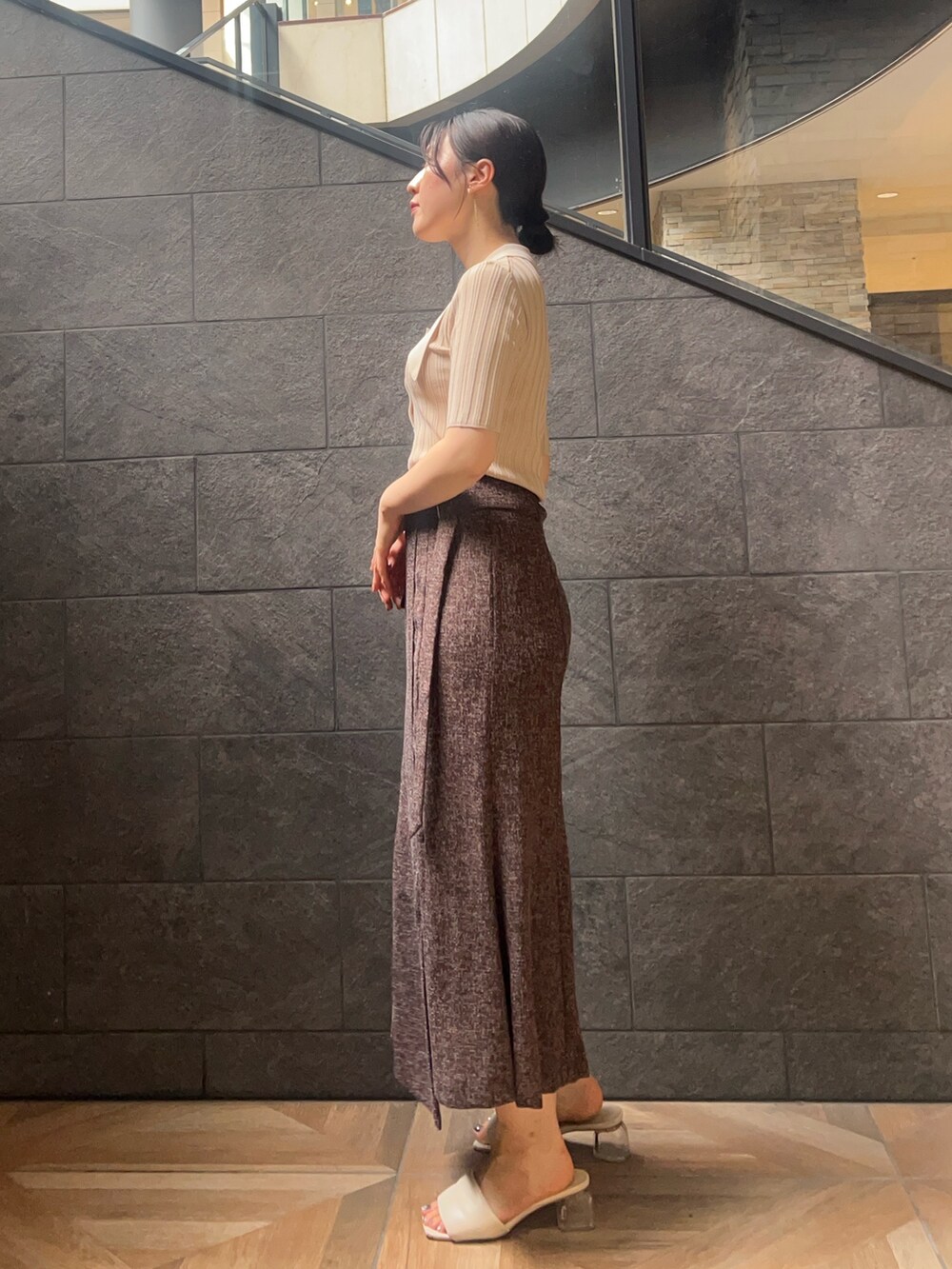 ベージュ系のニット/セーター、ブラウン系のスカートを着用したレディースの夏コーディネートの2枚目の写真