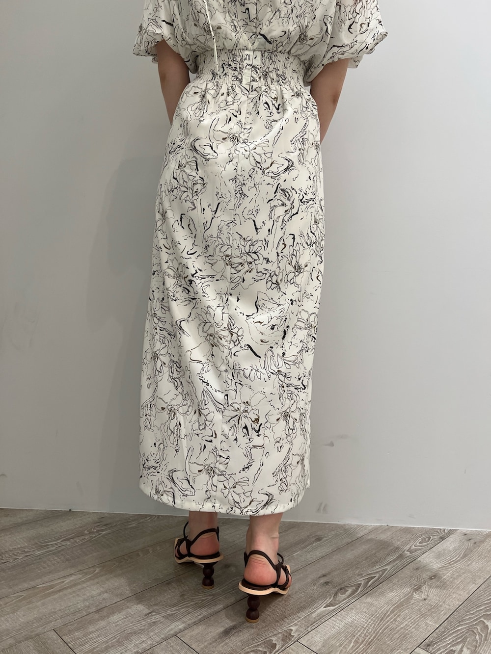 ブラウン系のサンダル、ホワイト系のショルダーバッグ、ホワイト系のワンピースを着用したレディースの春コーディネートの7枚目の写真