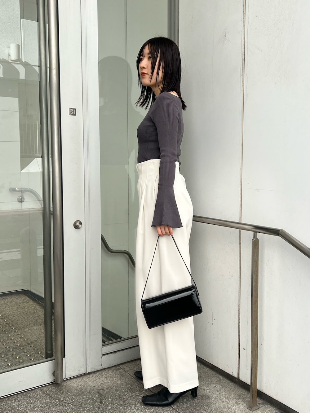 ブラック系のブーツ、ブラック系のショルダーバッグ、グレー系のカーディガン/ボレロを着用したレディースの秋コーディネートの3枚目の写真