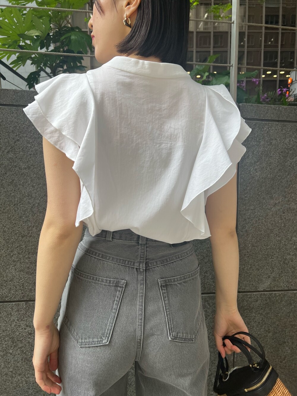 シルバー系のパンプス、グレー系のデニムパンツ、ホワイト系のシャツ/ブラウスを着用したレディースの春コーディネートの5枚目の写真