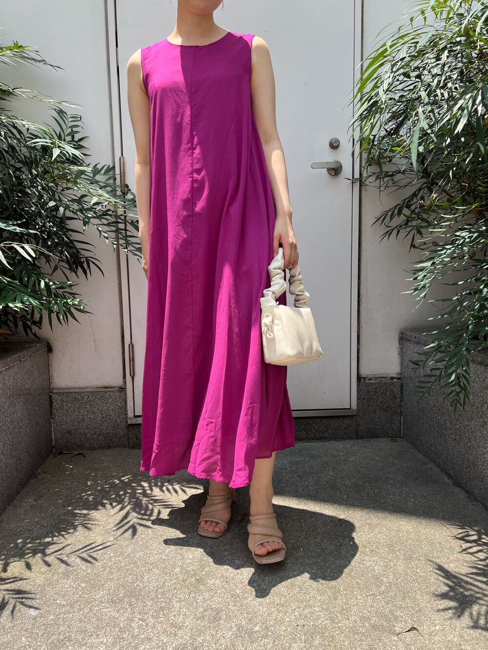 ベージュ系のサンダル、ホワイト系のハンドバッグ、パープル系のワンピースを着用したレディースの夏コーディネートの6枚目の写真