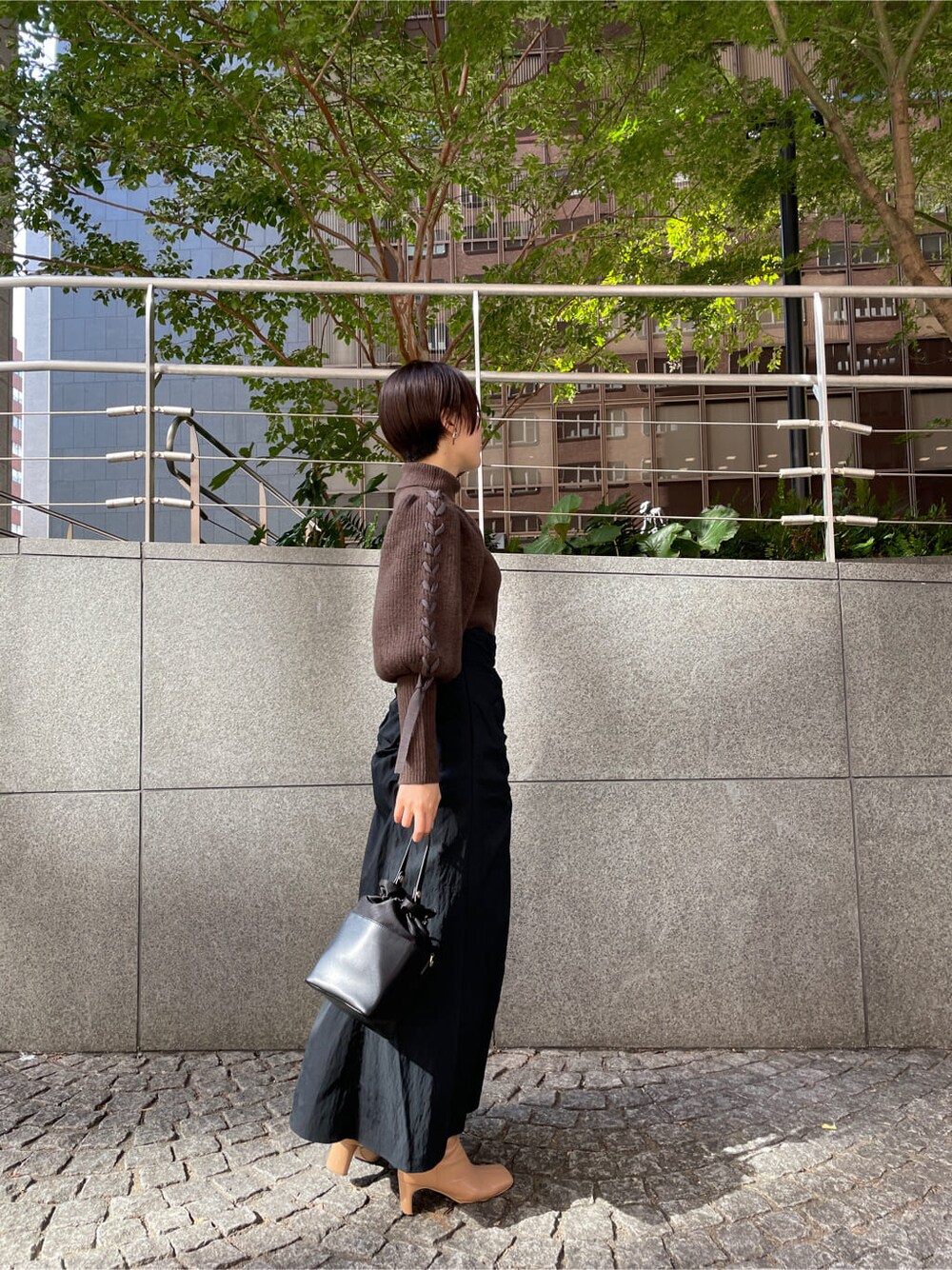 ベージュ系のその他シューズ、ホワイト系のその他アウター、ブラック系のスカートを着用したレディースの秋コーディネートの4枚目の写真