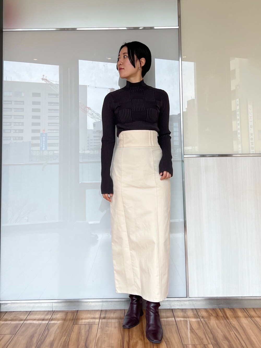 ホワイト系のスカート、グレー系のカーディガン/ボレロ、グレー系のニット/セーターを着用したレディースの冬コーディネートの2枚目の写真