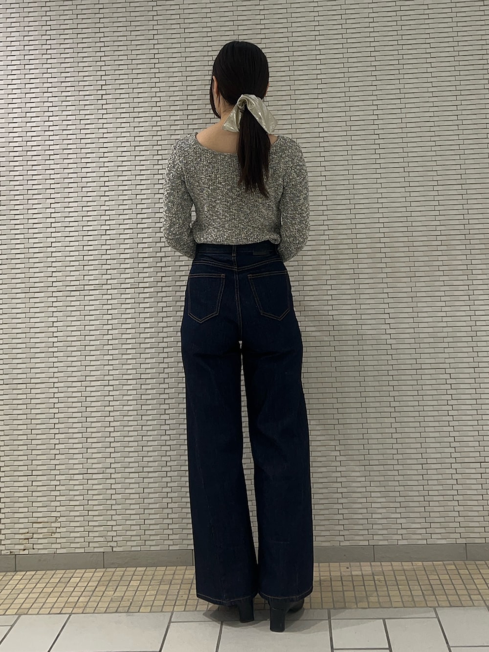 ブルー系のデニムパンツ、グレー系のニット/セーターを着用したレディースの冬コーディネートの3枚目の写真