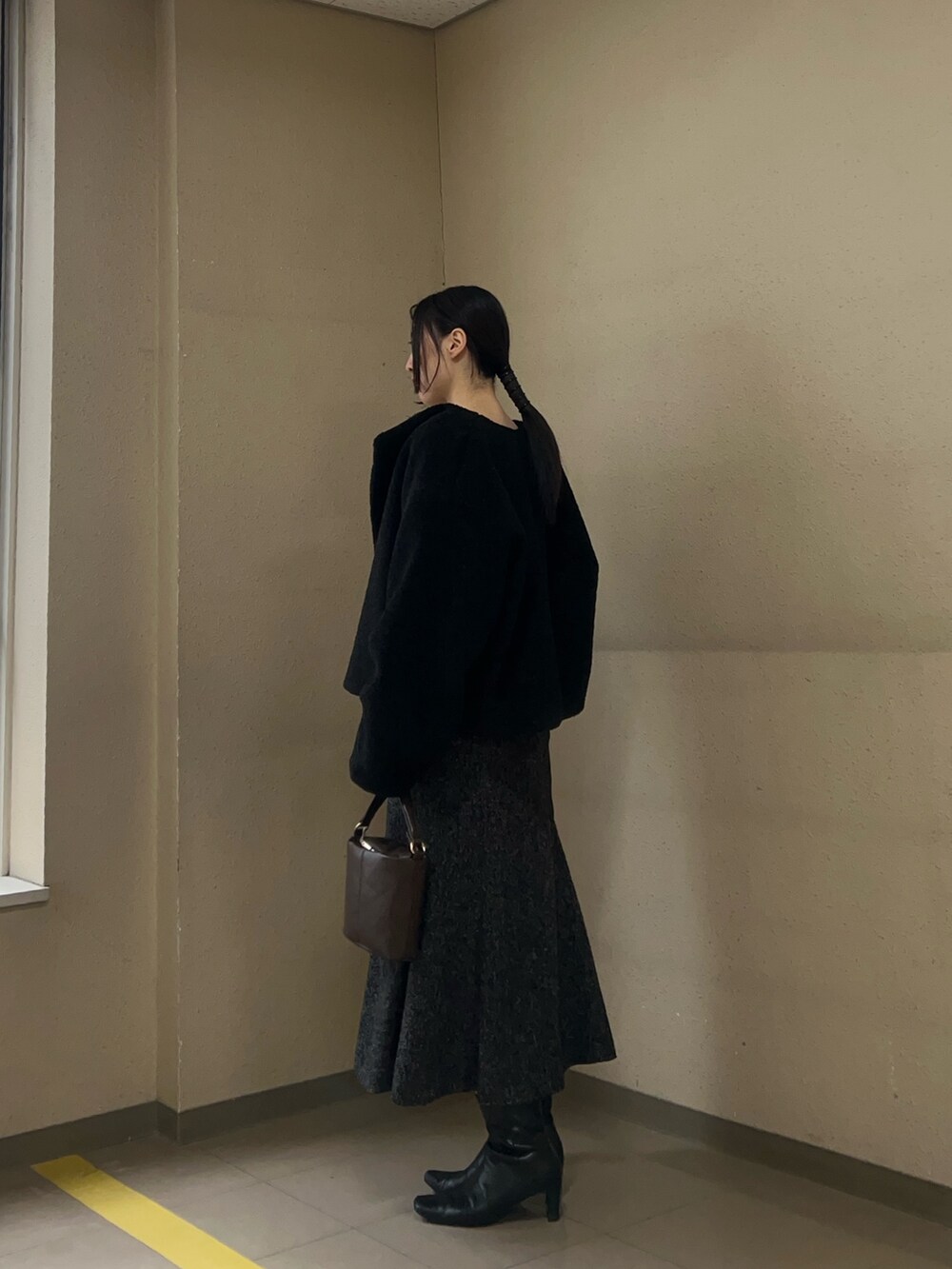 ブラック系のブルゾン、ホワイト系のニット/セーター、ブラック系のワンピースを着用したレディースの冬コーディネートの2枚目の写真