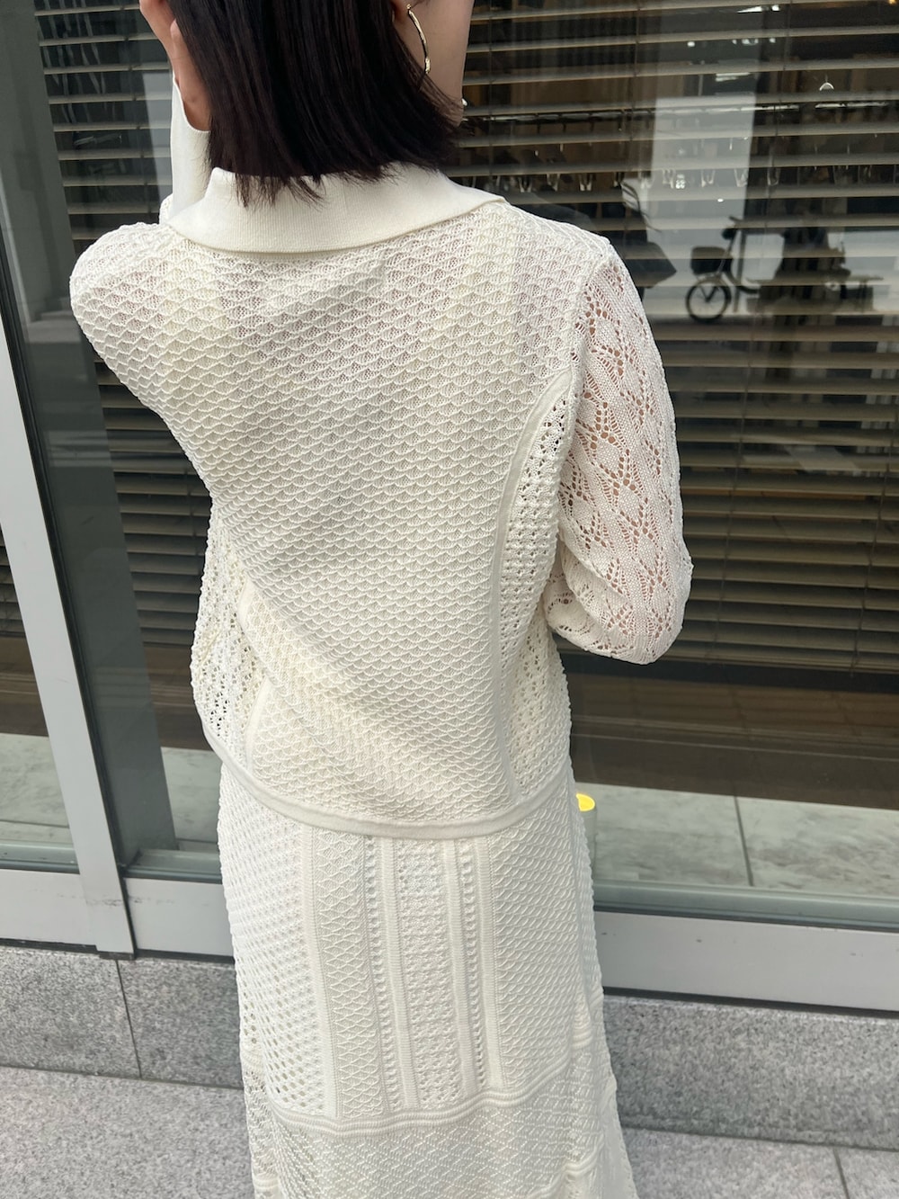 ブラウン系のショルダーバッグ、ホワイト系のカーディガン/ボレロ、ホワイト系のTシャツ/カットソーを着用したレディースの春コーディネートの8枚目の写真