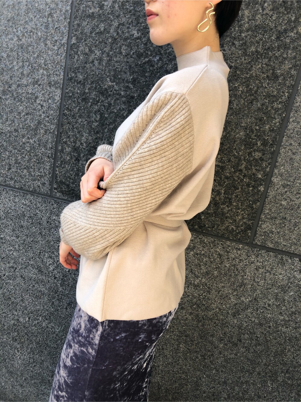 グレー系のスカート、ゴールド系のピアス（両耳用）を着用したレディースの冬コーディネートの3枚目の写真