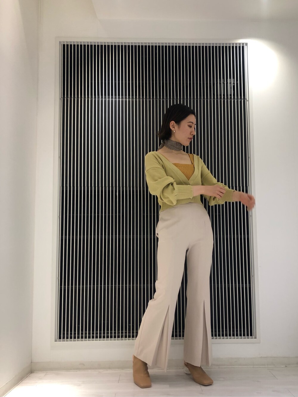 ベージュ系のその他パンツ、ベージュ系のブーツ、イエロー系のニット/セーターを着用したレディースの冬コーディネートの2枚目の写真