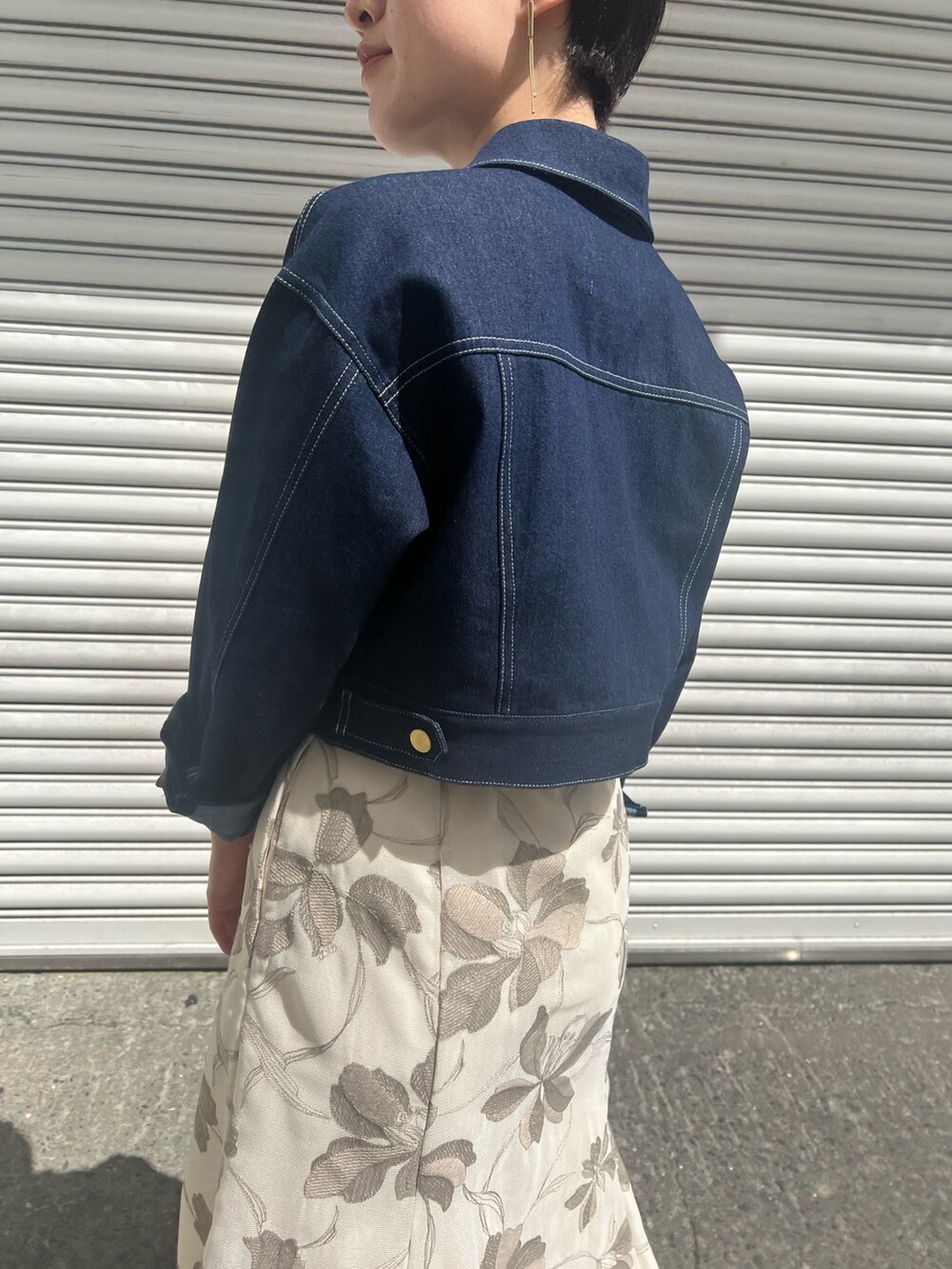 グリーン系のハンドバッグ、ホワイト系のニット/セーター、ベージュ系のサンダルを着用したレディースの春コーディネートの5枚目の写真